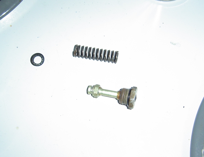 Brake caliper piston and spring on white surface
