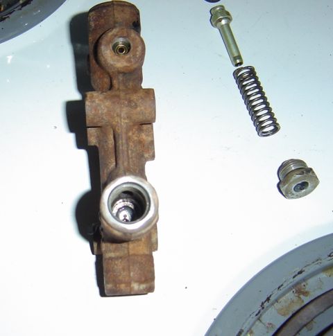 1986 Ford Bronco - Disassembled brake master cylinder part, showing rust and internal components.
