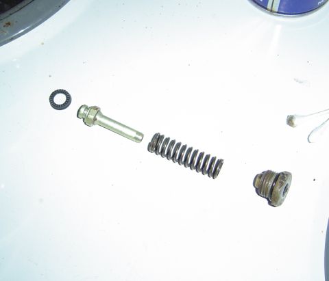 1986 Ford Bronco - Disassembled brake caliper components laid out on a white surface, with a Supermotors.net watermark.