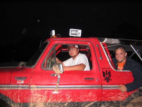 1979 Ford Bronco - Two men pose inside a mud-covered red 1979 Ford Bronco, ready for off-road adventure.