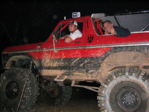 1979 Ford Bronco - Two men in a red, mud-covered 1978 Ford Bronco, ready for off-road adventure.