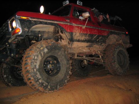 1979 Ford Bronco - Mud-covered 1978 Ford Bronco tackles rough terrain with a driver giving a thumbs-up.