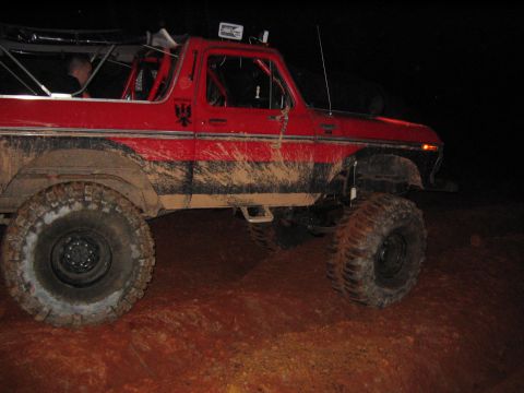 1979 Ford Bronco - This red Ford Bronco is covered in mud after off-roading at night.