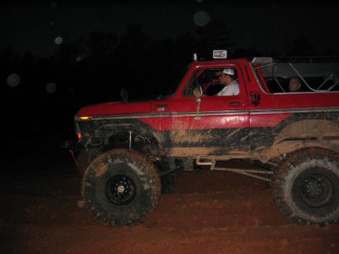 1979 Ford Bronco - Mud-covered off-road SUV driving at night.