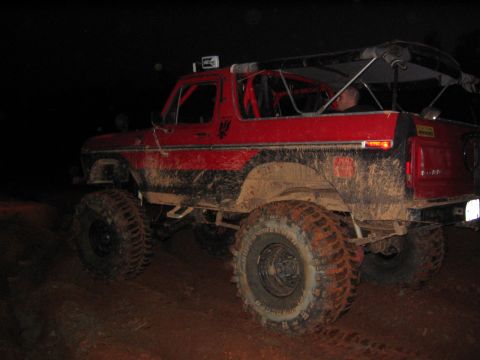 1979 Ford Bronco - This modified 1979 Ford Bronco is shown off-road at night, caked in mud.
