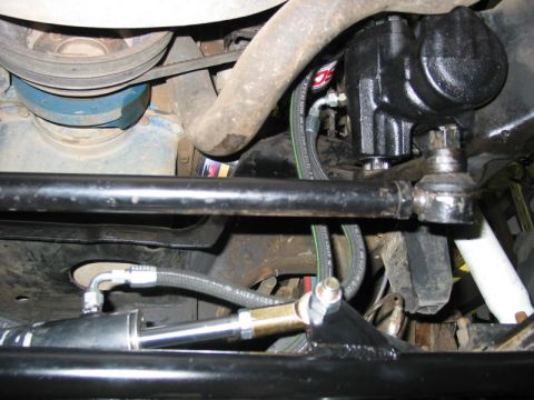 1981 Ford Bronco - Close-up view of a vehicle's hydro assist steering system, showing the power steering cylinder and associated linkages.