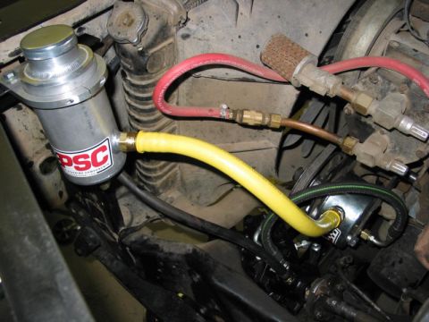1981 Ford Bronco - Close-up of a PSC power steering assist cylinder with associated hoses and fittings.