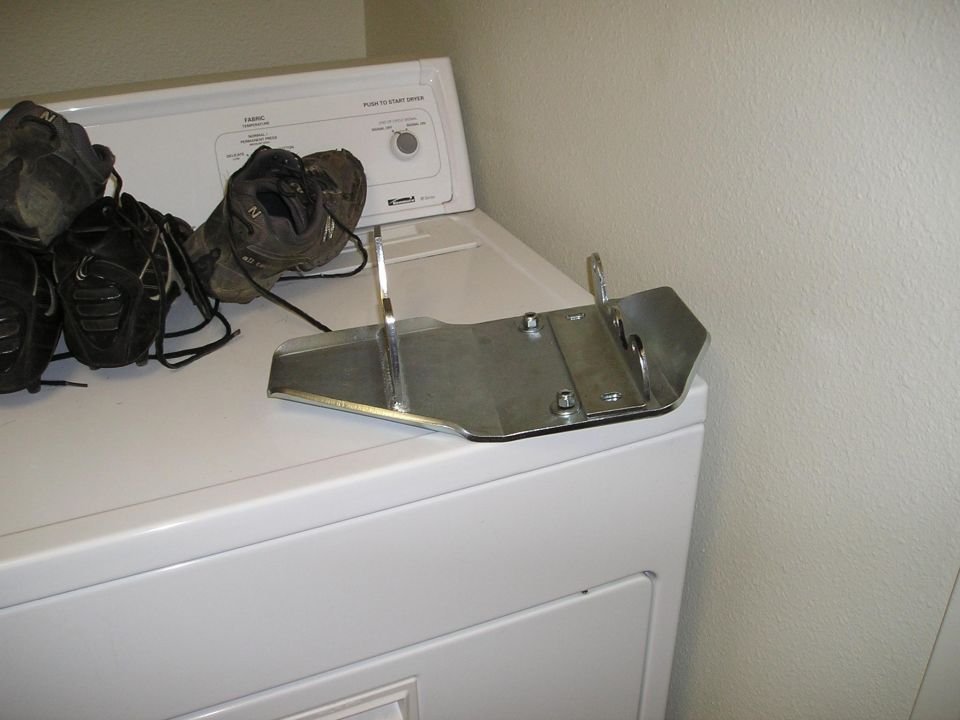 Metal skid plate and pair of shoes on top of a white dryer