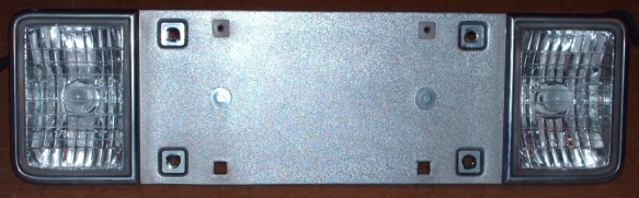 License plate panel with clear reverse light lenses at each end, removed from vehicle