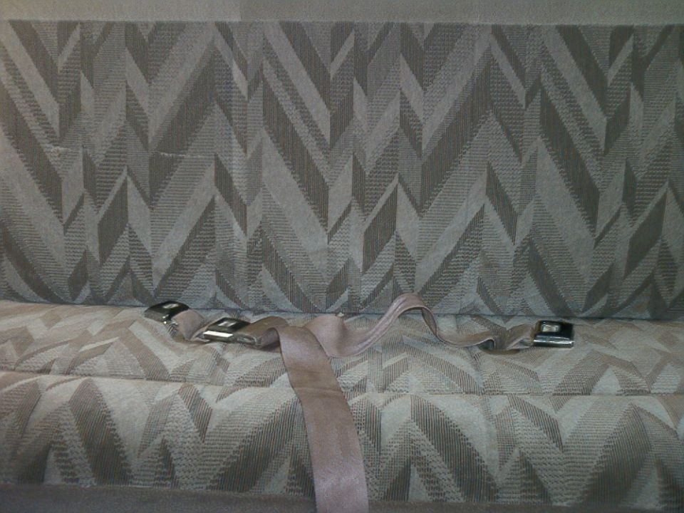 Seatbelt buckle and strap on patterned upholstery