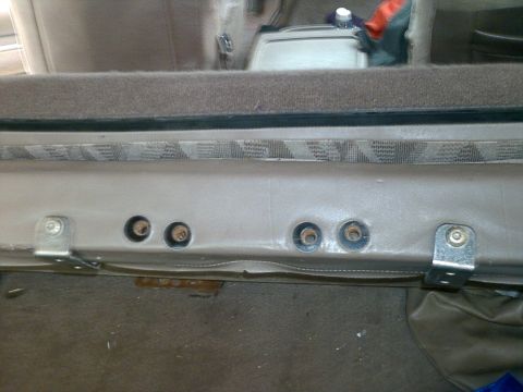 1995 Ford Bronco - The photo shows the interior of a vehicle, focusing on the seat mounting hardware and carpeted floor.