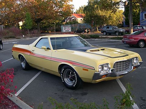 1973 Ford Ranchero - This classic Ford Ranchero features a distinctive grille and side stripe, parked in a lot with other vehicles.