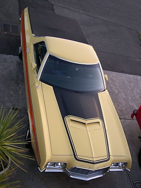 1973 Ford Ranchero - A yellow Ford Ranchero with a distinctive stripe package is parked on a driveway.
