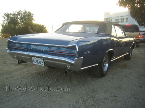 1968 Ford Mustang - Rear view of a blue 1966 Pontiac GTO convertible with a black soft top.