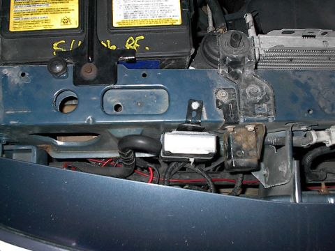 1985 Mercury Grand Marquis - Close-up view of engine bay components, including the battery and radiator, with visible wiring and mounting brackets.