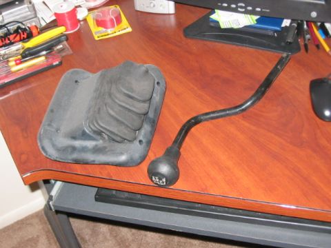 1991 Ford Bronco - A gear shifter and boot are displayed on a desk, separate from any vehicle.