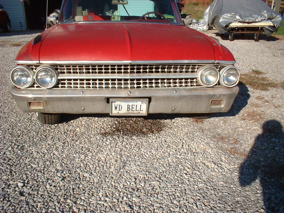 Front of red vintage Ford with chrome grille and Virginia 'WD BELL' plate on gravel
