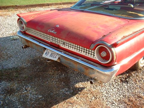 1961 Ford Starliner - Rear view of a red 1961 Ford Galaxie showing its distinctive taillights and grille, with a license plate reading 'WD BELL'.