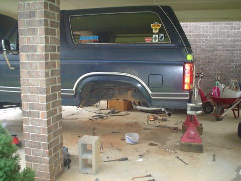1984 Ford Bronco - Ford Bronco undergoing rear axle repair in a garage setting.