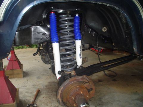 1984 Ford Bronco - Close-up of a vehicle's lifted suspension system, showing new shocks and springs.