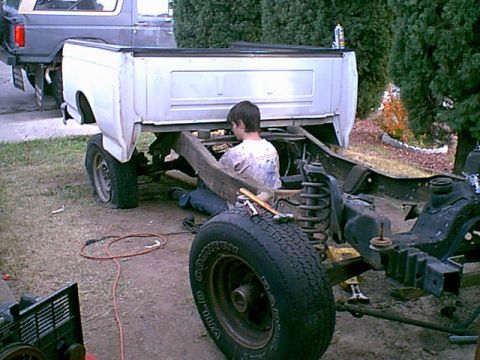 1983 Ford Bronco - well this was at noon. we had the cab and most of the truck stripped down. here is my oldest son removing the bed bolts.