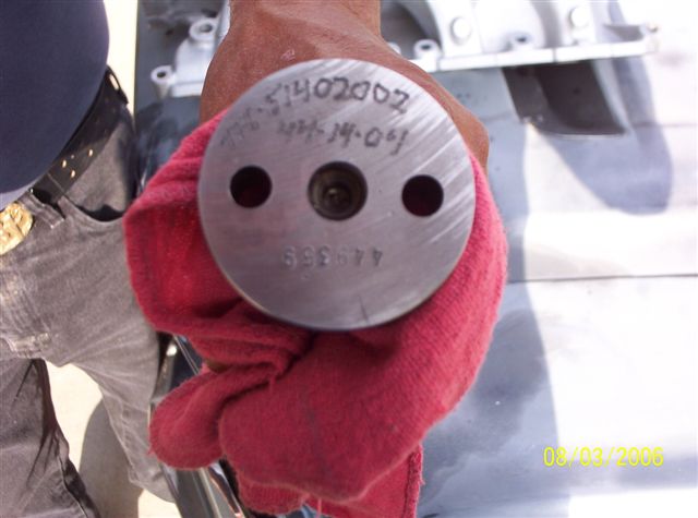 Metal part with stamped numbers '51402002', '44-14-04', and '699359', held by a red cloth