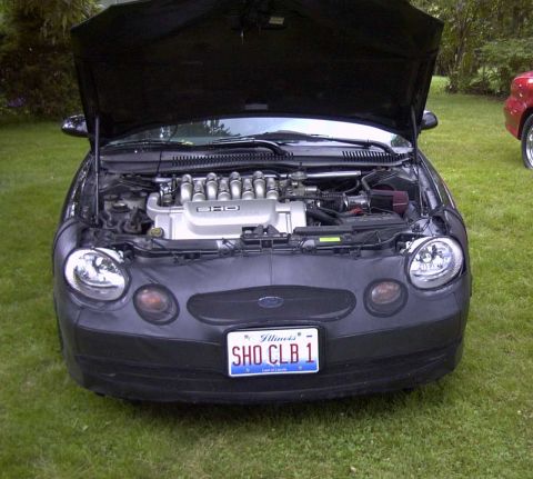 1997 Ford Taurus - Front view of a 1997 Ford Taurus SHO, hood open, revealing the V8 engine. Another vehicle is visible to the right.