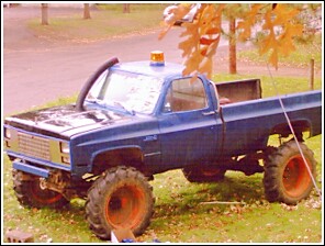 1976 Chevrolet Silverado 2500 - Modified pickup truck with large tires and snorkel exhaust pipe.