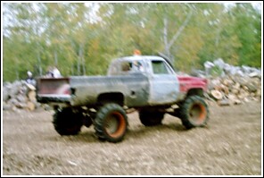 1976 Chevrolet Silverado 2500 - This heavily modified pickup truck features oversized tires and a custom paint job, suggesting it's built for off-road use.