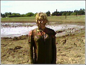 1976 Chevrolet Silverado 2500 - A woman is covered in mud after participating in a mud run event.