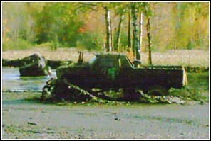 1976 Chevrolet Silverado 2500 - A heavily soiled 1976 Chevrolet Silverado 2500 truck sits in a muddy, watery environment.