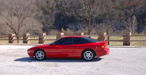 1996 Ford Probe - A red coupe is parked outdoors with a natural landscape in the background.