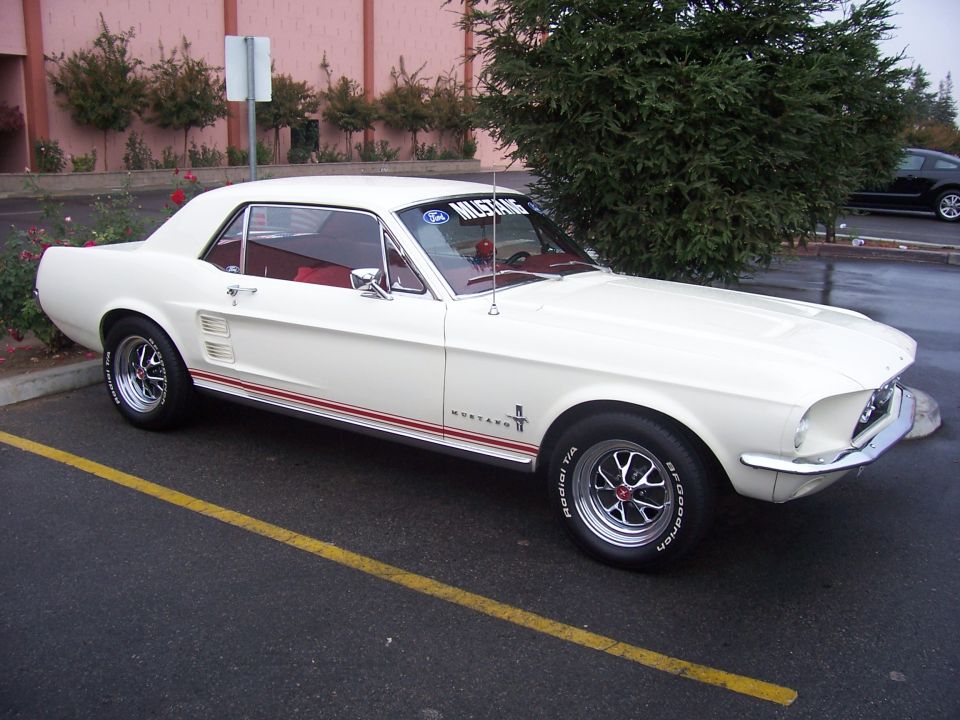 White 1967 Ford Mustang coupe with red stripes and chrome wheels