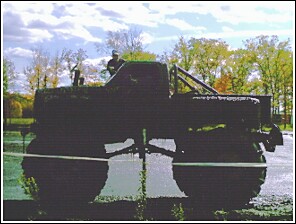 1976 Chevrolet Silverado 2500 - A modified truck with massive tires sits parked outdoors under a cloudy sky.