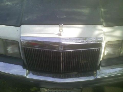 1989 Lincoln Continental - Close-up of the front grille and hood ornament of a Lincoln Mark VII.