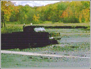 1976 Chevrolet Silverado 2500 - A truck is stuck in the mud during what appears to be a mud run event.