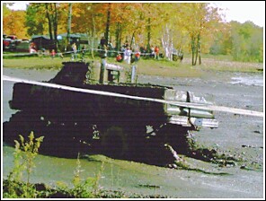 1976 Chevrolet Silverado 2500 - Pickup truck stuck in mud during an event, with spectators watching.