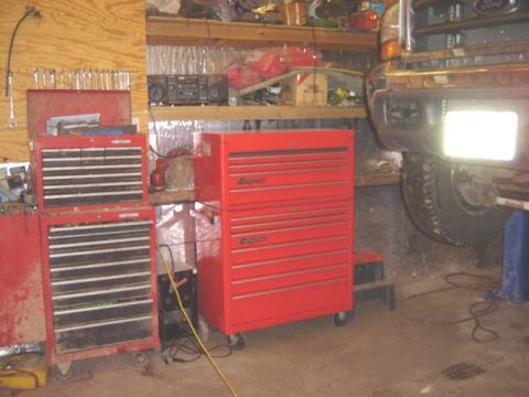 1992 Ford Bronco - A vehicle's front bumper is visible above red tool chests in a workshop setting.