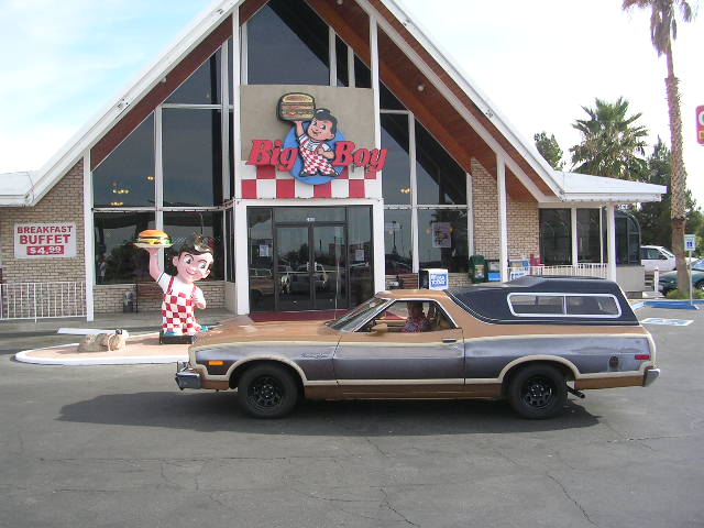Brown and grey Ford Ranchero with a black camper shell, parked in front of a Big Boy restaurant