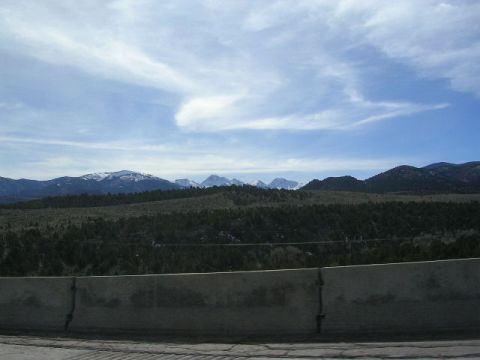 1975 Ford Ranchero - Scenic view of mountains and sky, with a concrete barrier along the roadside.