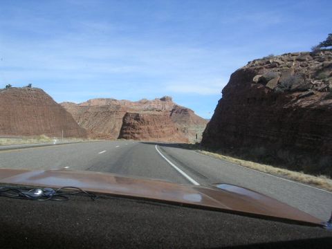 1975 Ford Ranchero - View from inside a vehicle driving on a highway through a scenic landscape of red rock formations under a clear blue sky.