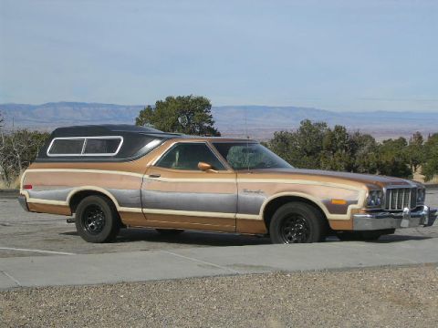 1975 Ford Ranchero - A 1975 Ford Ranchero pickup truck is seen from the side, equipped with a black camper shell.