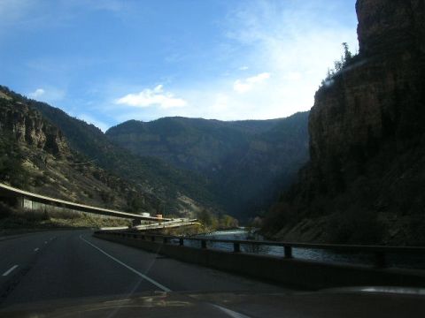 1975 Ford Ranchero - A scenic drive through a mountain pass with a river flowing alongside the highway.