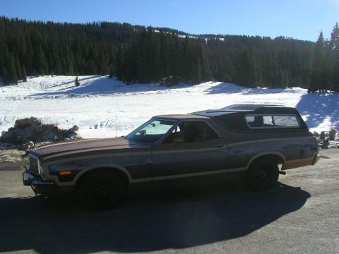 1975 Ford Ranchero - A 1975 Ford Ranchero is parked in a snowy area with pine trees in the background.