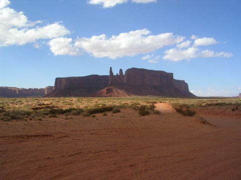 1975 Ford Ranchero - Monument Valley landscape with iconic buttes and mesas under a bright blue sky with scattered clouds.