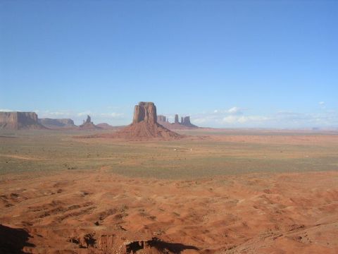 1975 Ford Ranchero - Iconic buttes of Monument Valley under a vast blue sky, with red desert terrain in the foreground.