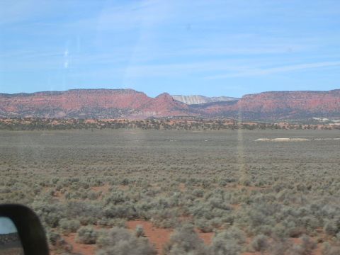 1975 Ford Ranchero - A wide shot of a desert landscape with mesas in the distance, taken from inside a vehicle.