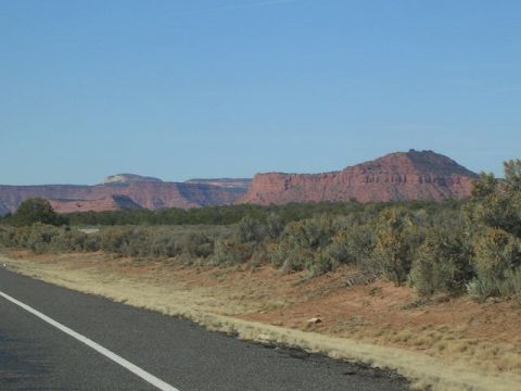 1975 Ford Ranchero - A scenic desert view with mesas in the distance, seen from the side of a road. The Supermotors.net logo is visible in the lower right corne…