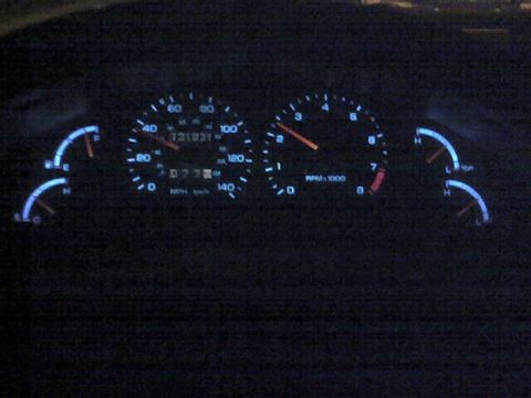 1994 Ford Probe - Illuminated dashboard gauges show speed, RPM, fuel level, and temperature.