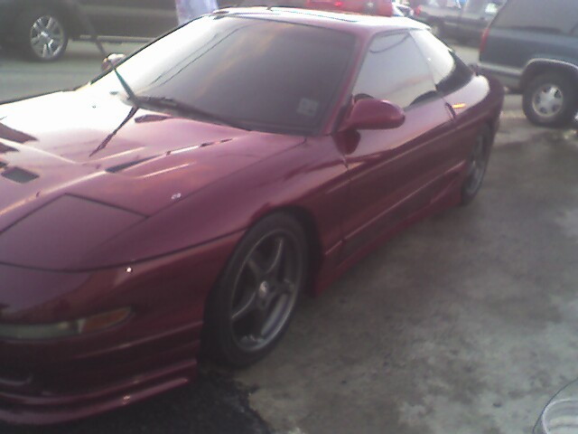 maroon coupe parked outside, other cars in background